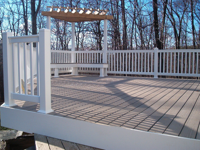 Gray deck with white vinyl railing and bench seating