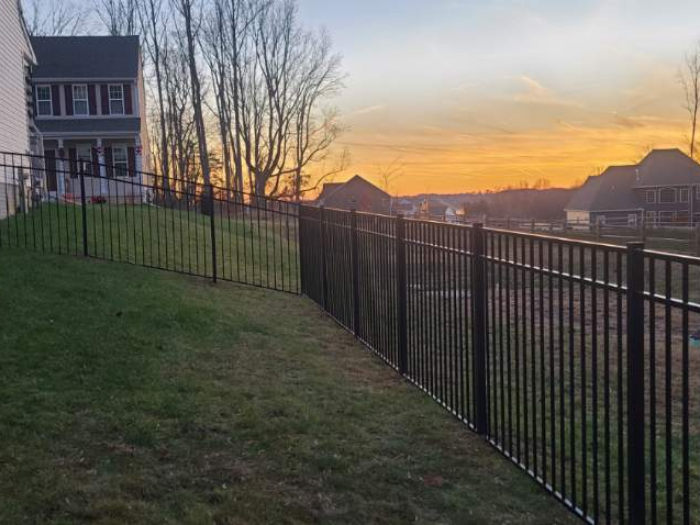 Black aluminum fence at sunset