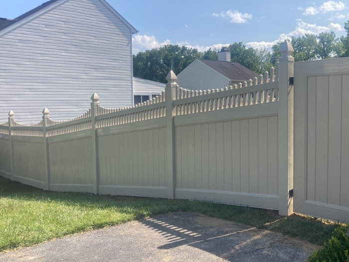 Tan vinyl privacy fence with scalloped top